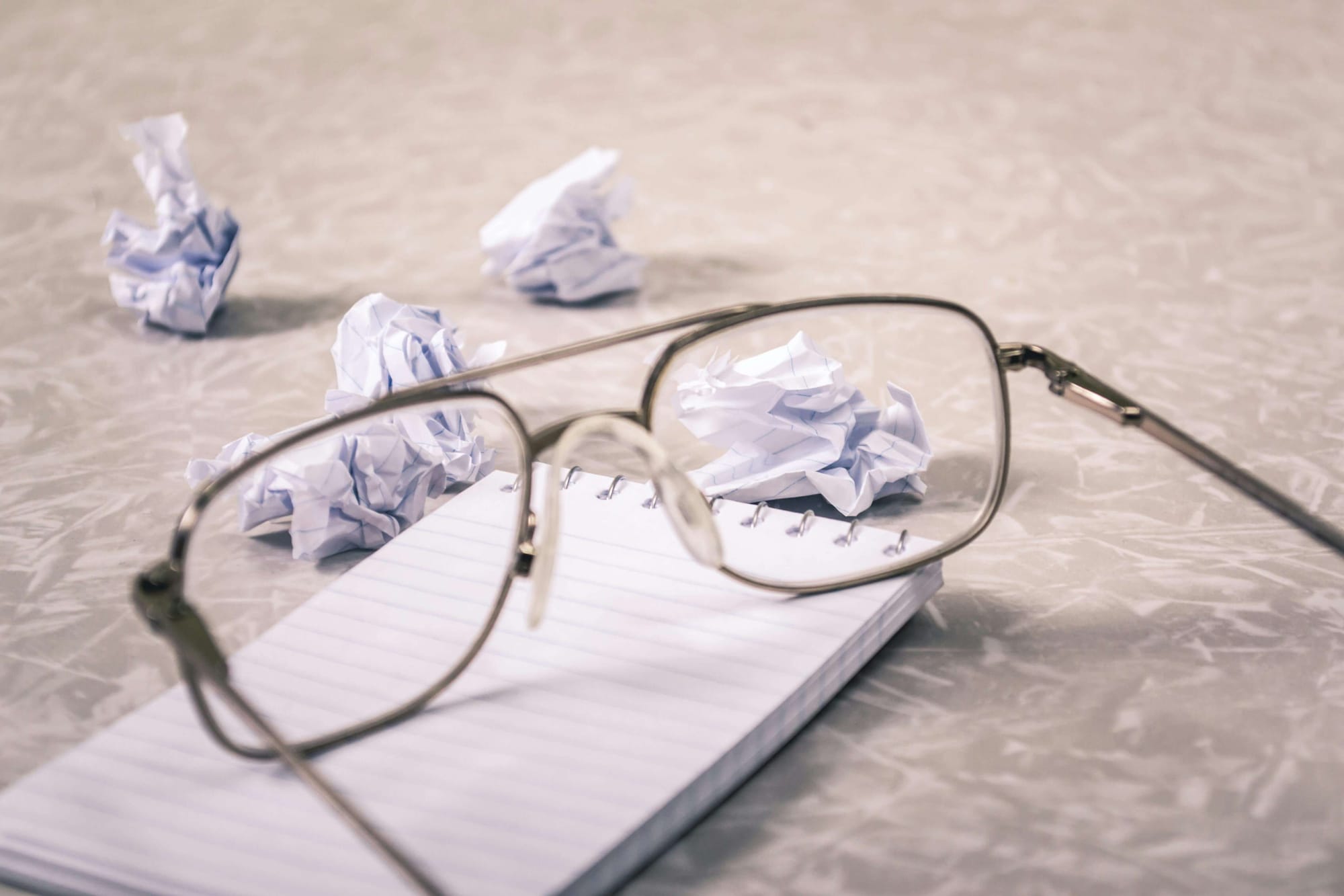 close-up-photography-of-eyeglasses-near-crumpled-papers