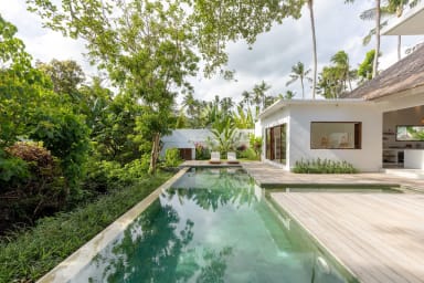 View onto the private infinity swimming pool surrounded by a wooden deck and...