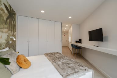 Schlafzimmer mit einem Doppelbett und einem TV