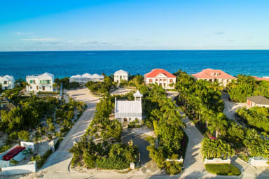 Aerial view of Nutmeg Cottage (white) facing Grace Bay Beach.