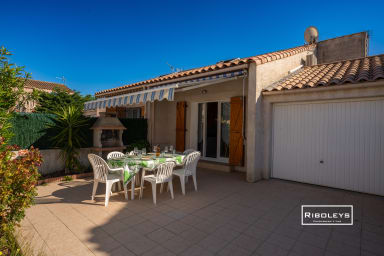 Terrace with garden furniture, charcoal barbecue and awning