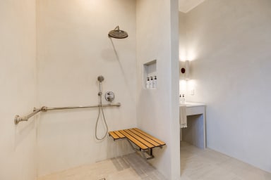 En-suite ADA bathroom with rain shower and high-end toiletries