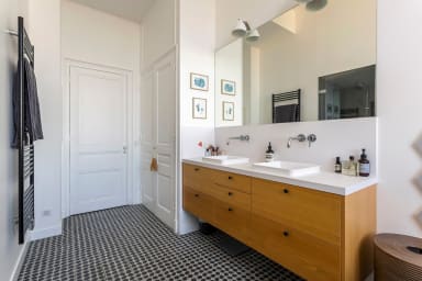 Première salle de bain équipée de 2 vasques, un sèche serviette, une douche...