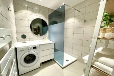 Salle d'eau avec WC, grande douche à l'italienne, lave linge et sèche serviette.