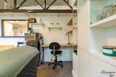 Pièce à vivre avec coin bureau, télé et canapé et quelques rangements