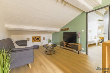 Espace séjour avec télévision et plafond en pente