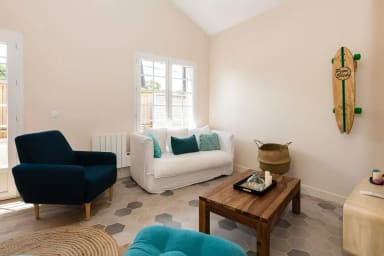 Salon avec tv, canapé et fauteuils