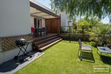 Jardin clôturé avec grande terrasse et passerelle en bois