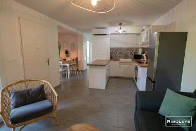 Grande pièce de vie climatisée avec cuisine ouverte et wifi