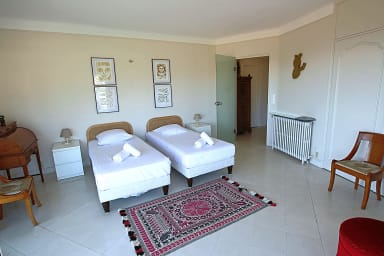Large, air-conditioned bedroom with two single beds, opening onto a terrace.