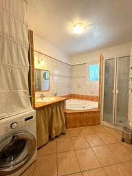 Salle de bain avec baignoire, douche, machine à laver