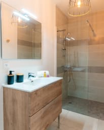 Salle de bain avec douche vitrée et meuble vasque