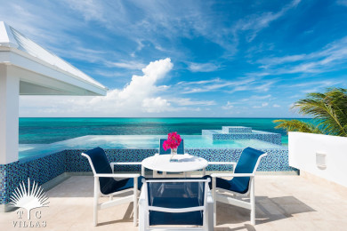 Plum Wild's outdoor dining table with views of Grace Bay Beach. 