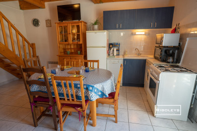 Cuisine équipée avec table à manger, tv, fauteuil et climatisation