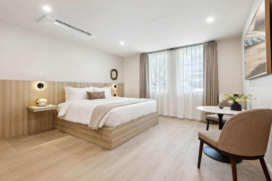 King bed with small table and 65 inch Hisense Smart TV