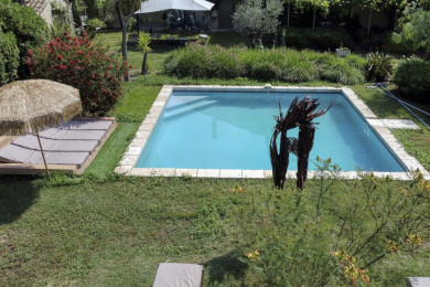 piscine partagée entourée d’arbres et de fleurs