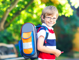 Kleiner Junge mit Schulranzen am ersten Schultag