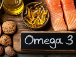 Omega-3-reiche Lebensmittel wie Lachs, Fischölkapseln, Chiasamen, Nüsse und Leinöl auf Holzuntergrund – Darstellung gesunder Ernährung zur Unterstützung der Herzgesundheit und Versorgung mit Omega-3-Fettsäuren.