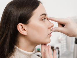 Arzt untersucht die Nase einer Patientin im Profil und prüft Nasenform und Gesichtsproportionen vor einer möglichen Nasenoperation.