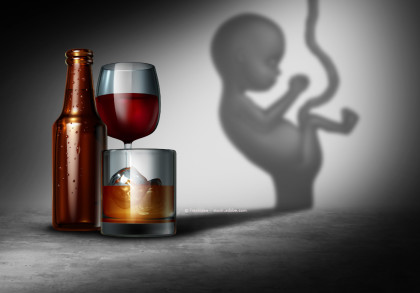 Ein braunes Bierflasche, ein Glas Rotwein und ein Glas Whiskey mit Eiswürfeln stehen auf einem betonartigen Untergrund. Die Flasche und Gläser werfen einen Schatten in Form eines Fötus an die Wand im Hintergrund.