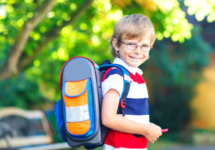 Kleiner Junge mit Schulranzen am ersten Schultag