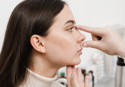 Arzt untersucht die Nase einer Patientin im Profil und prüft Nasenform und Gesichtsproportionen vor einer möglichen Nasenoperation.