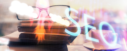 Symbolbild für SEO mit Fokus auf Online-Marketing im Gesundheitswesen: Überlagerte Schrift „SEO“, Bücherstapel mit Brille und Kaffeetasse im Hintergrund, abstrakte Lichteffekte.