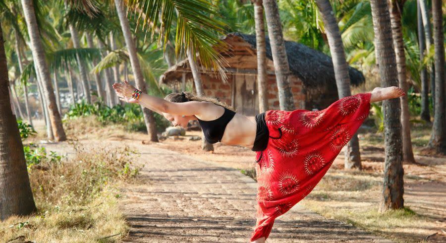 Yoga virabhadrasana warrior pose by beautiful Caucasian woman, India, Kerala, Varkala, Asia