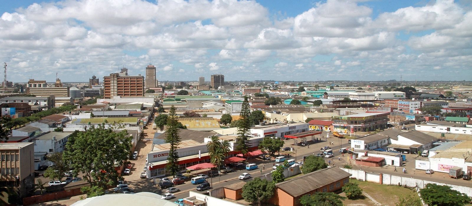 City view of Lusaka, Zambia with buildings and streets under a partly cloudy sky.
