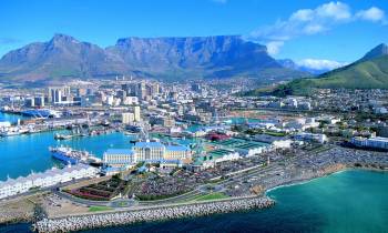 a harbor filled with blue water and a mountain in the background