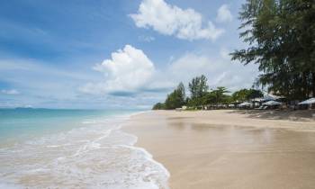 a sandy beach next to a body of water