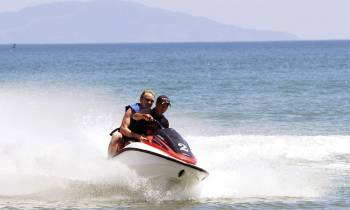 a man riding on the back of a boat in a body of water