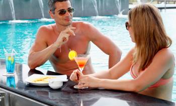 a woman sitting at a table with people in the water