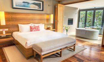 a bedroom with a bed and a chair in a room