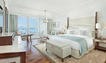 a bedroom with a bed and a chair in a room