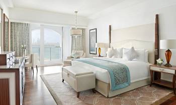 a bedroom with a bed and chair in the living room