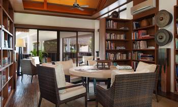 a dining room table in front of a book shelf