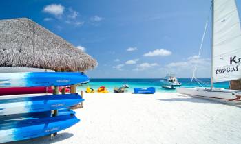 a blue and white boat sitting on top of a beach