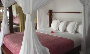 a bedroom with a bed and a chair in a room