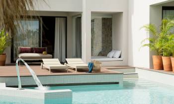 a large white tub sitting next to a pool