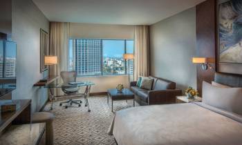 a bedroom with a bed and a chair in a room