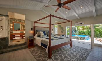 a bedroom with a bed and a chair in a room