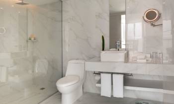 a white sink sitting under a mirror