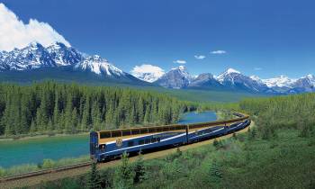 a train traveling down train tracks next to a body of water