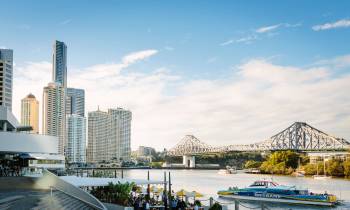 a bridge over a body of water with a city in the background