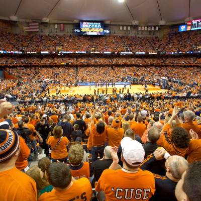 a large crowd of people with Carrier Dome in the background