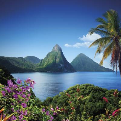 a large body of water surrounded by trees with Pitons in the background