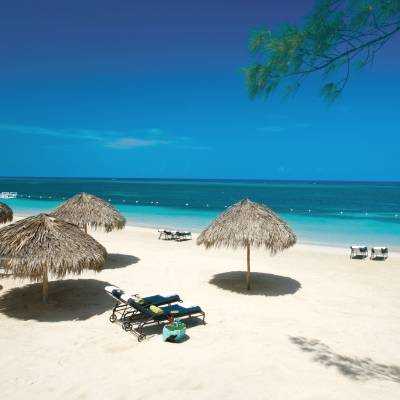 a group of lawn chairs sitting on top of a sandy beach