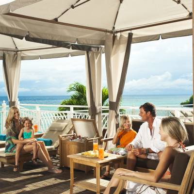 a group of people sitting at a table in front of the ocean