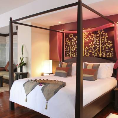a bedroom with a bed and a chair in a room